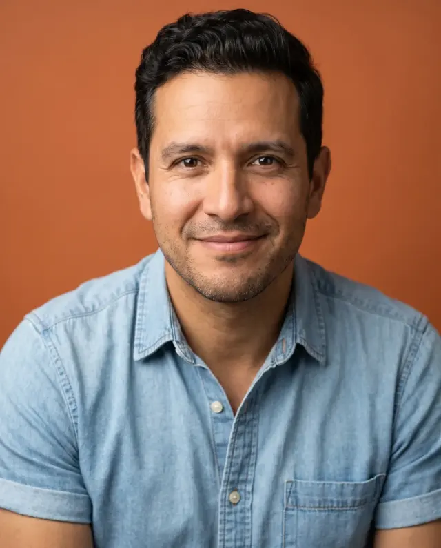 Actor headshot of a man in a chambray shirt on a burnt-orange backdrop