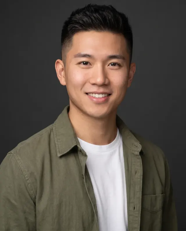Actor headshot of a young man in an olive overshirt and white T-shirt on a charcoal backdrop