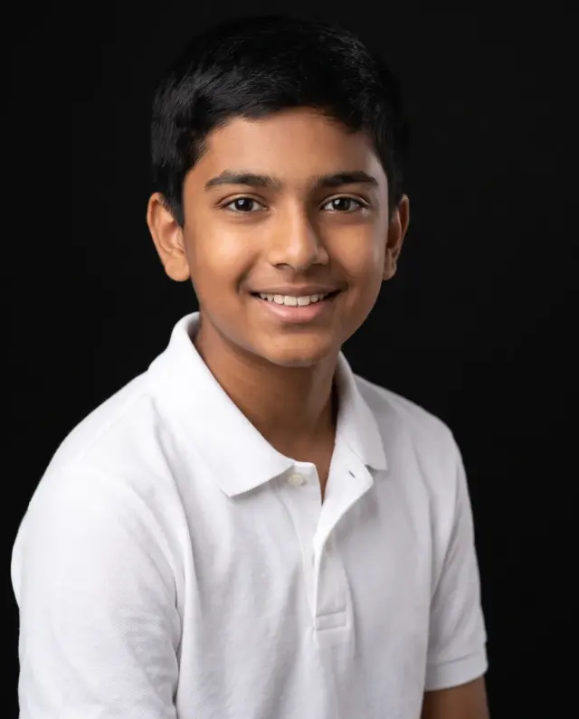 Young actor headshot of a boy in a white polo shirt on a black backdrop