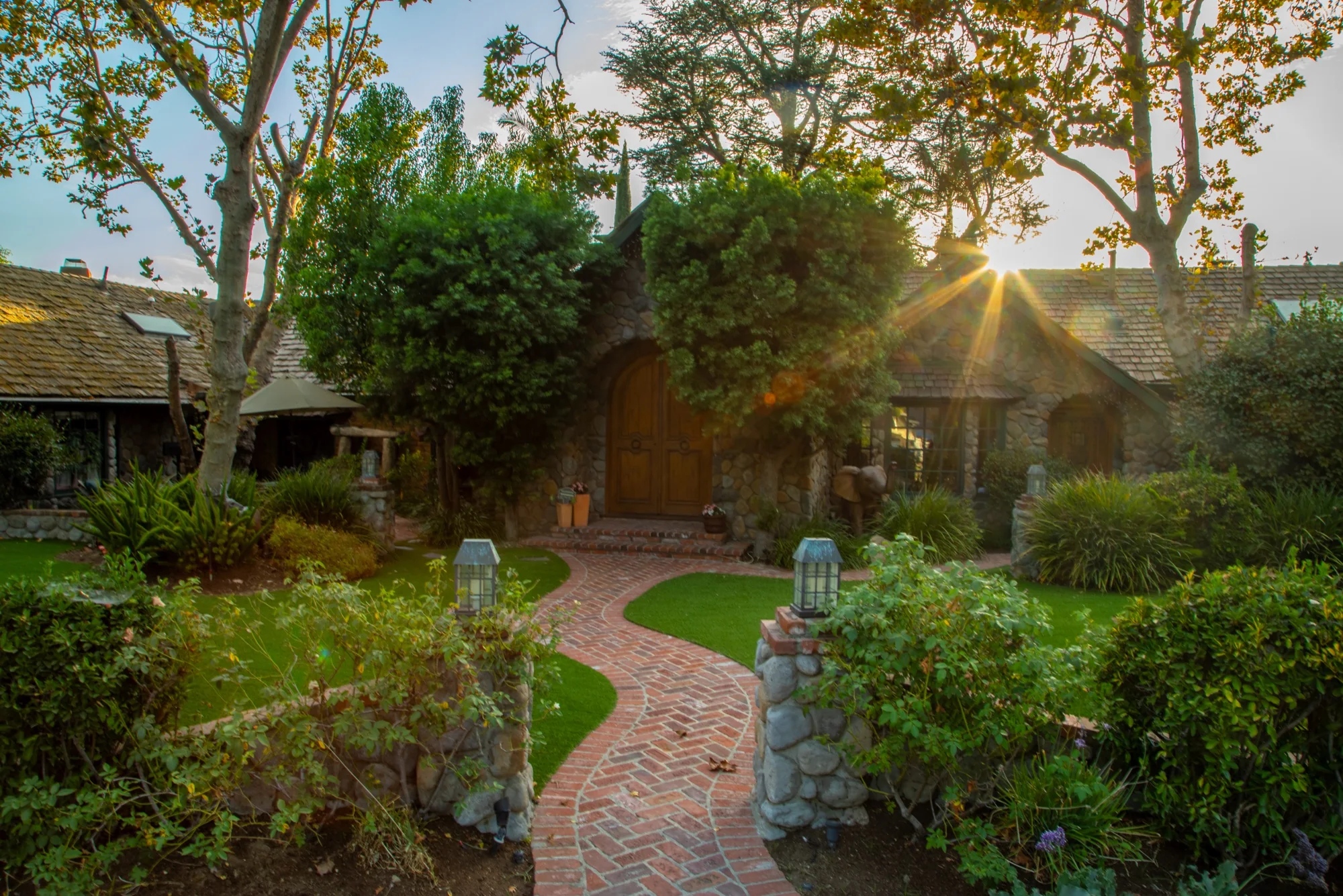 The brick path curving across the lawn to the front door at The Enchanted Manor