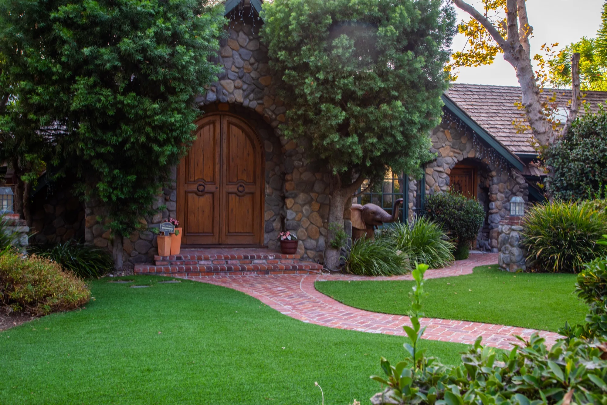 The arched oak doors of the stone cottage at The Enchanted Manor