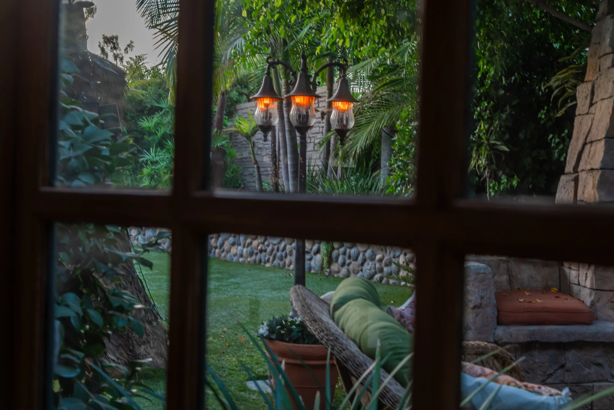 The gardens seen through a paned window at The Enchanted Manor