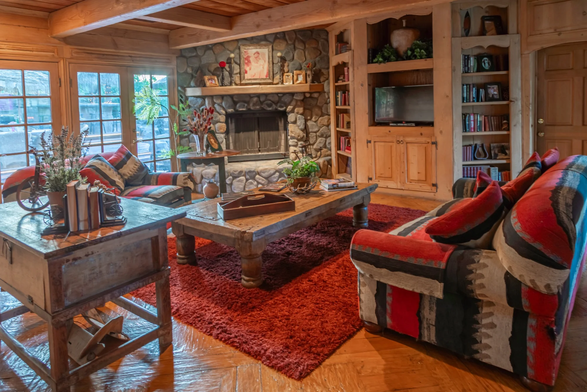 The wood-panelled great room and its stone fireplace at The Enchanted Manor