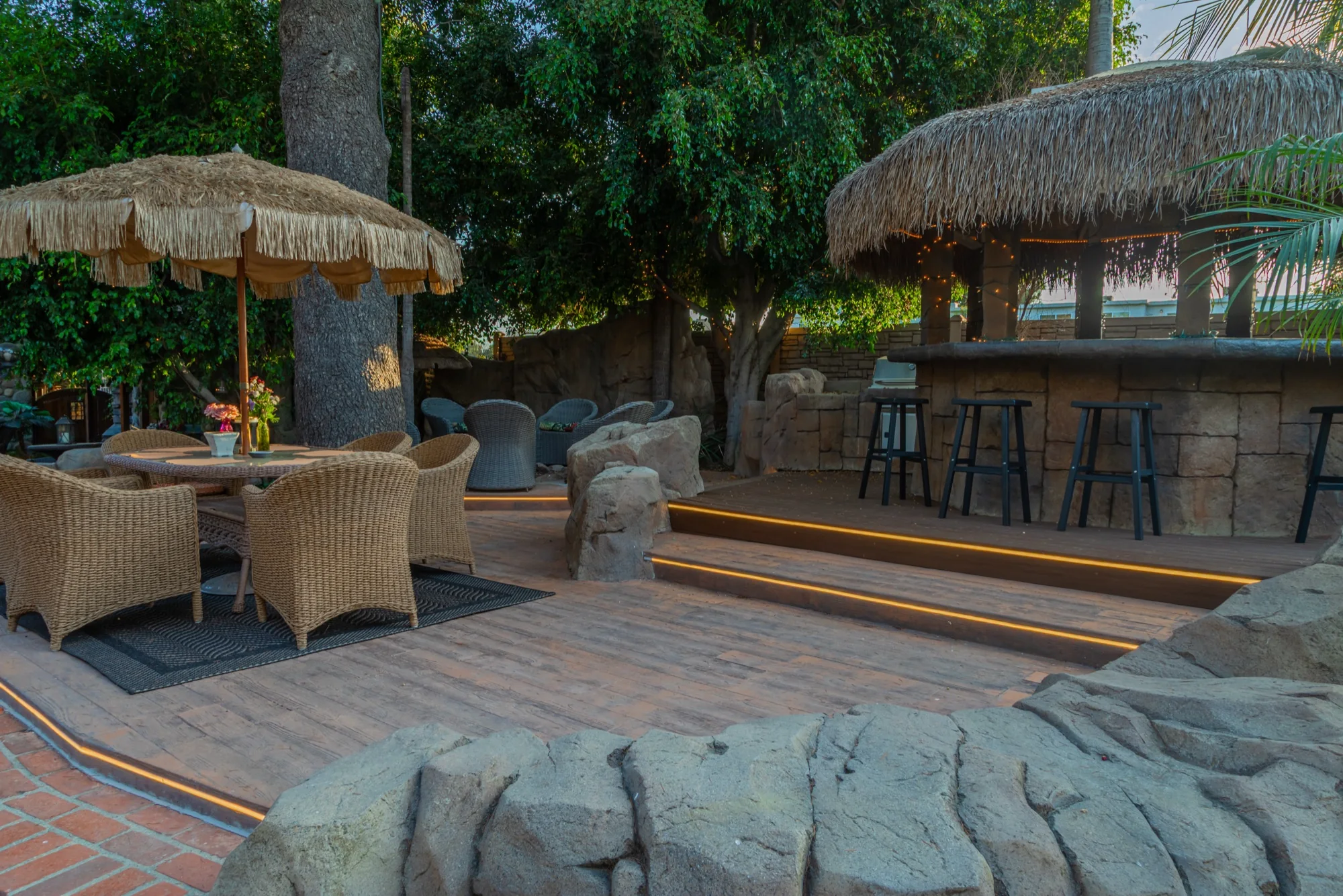 Tables under the palapas beside the gazebo bar at The Enchanted Manor