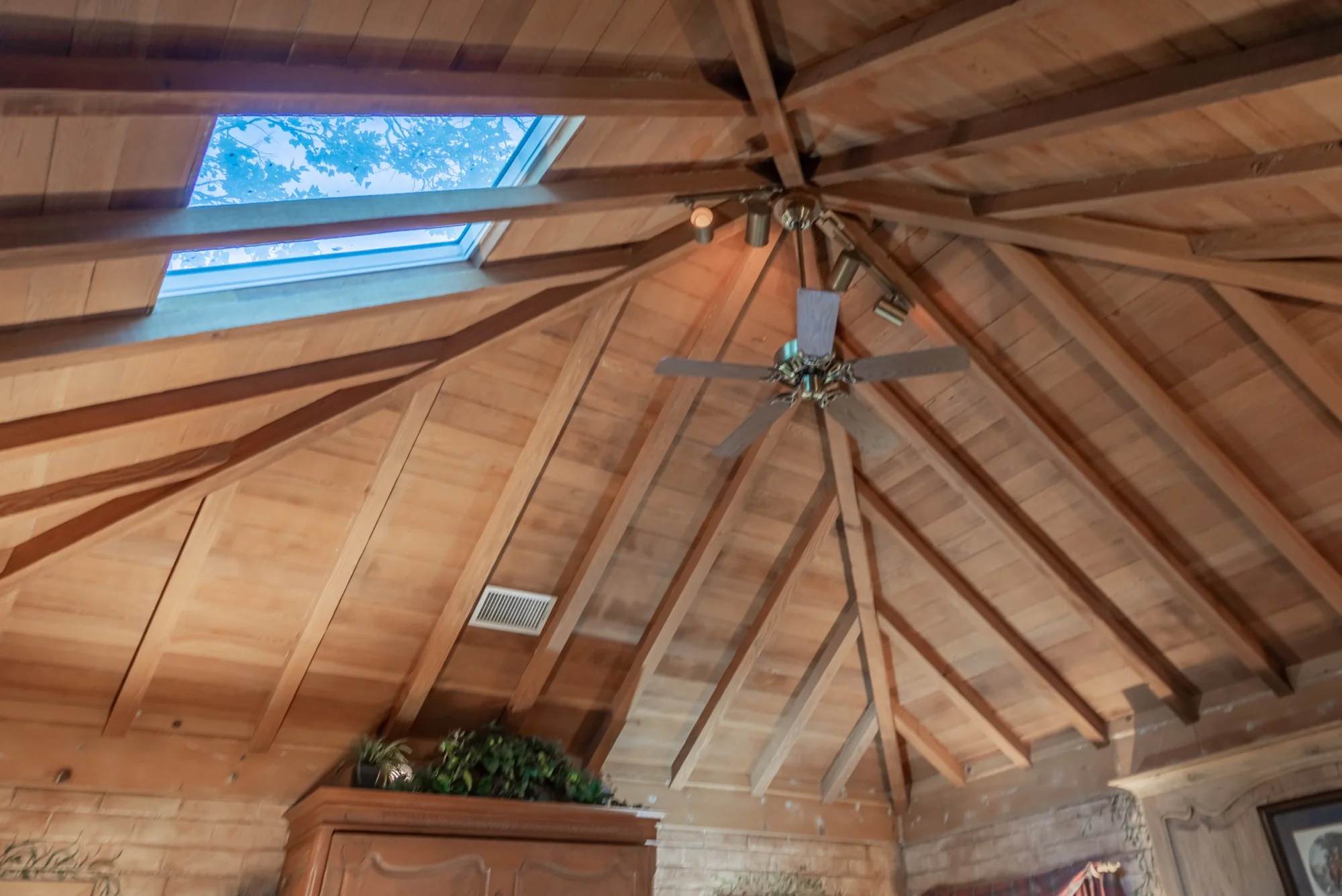 The vaulted wooden ceiling and skylights of the cottage at The Enchanted Manor