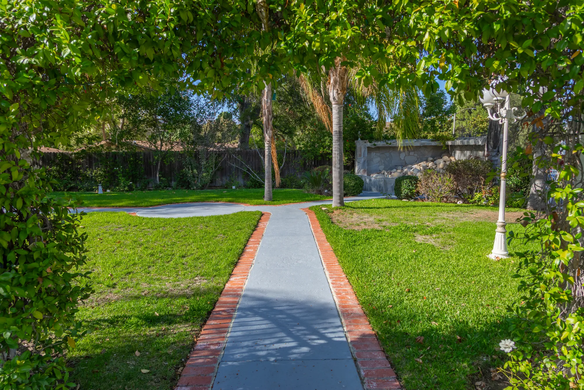 The brick-edged path running under the leafy arbor at Kelly's Wedding Garden