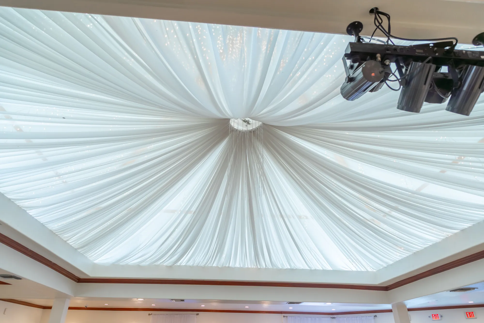The gathered white fabric ceiling and stage lights over the dance floor at Kelly's Wedding Garden