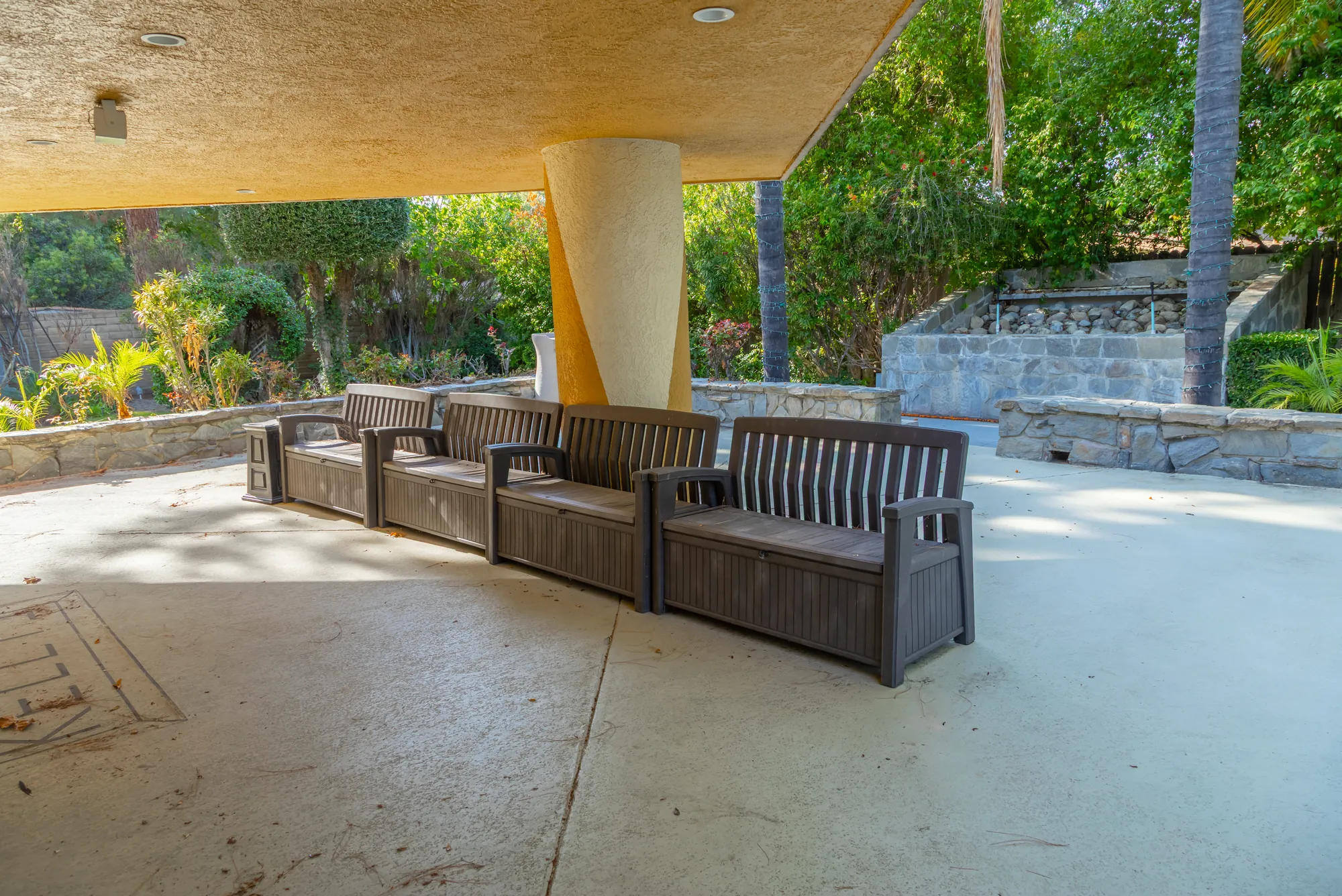 The covered patio with bench seating looking out to the garden at Kelly's Wedding Garden