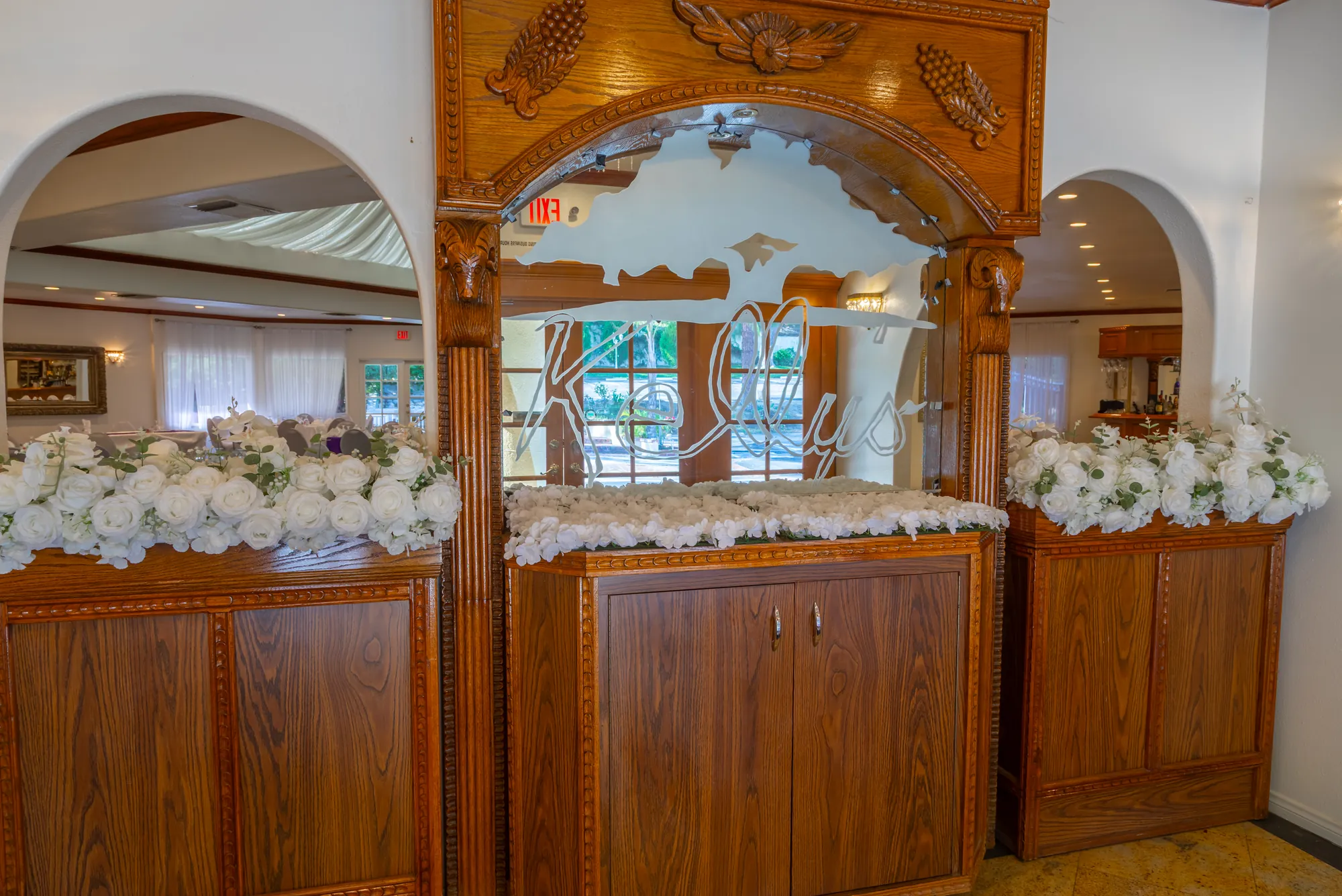 The carved oak entry cabinet with etched glass and white roses at Kelly's Wedding Garden