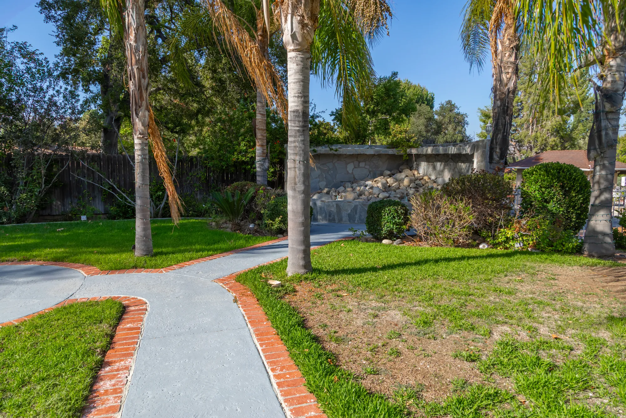 Garden paths forking across the lawn under the palms at Kelly's Wedding Garden