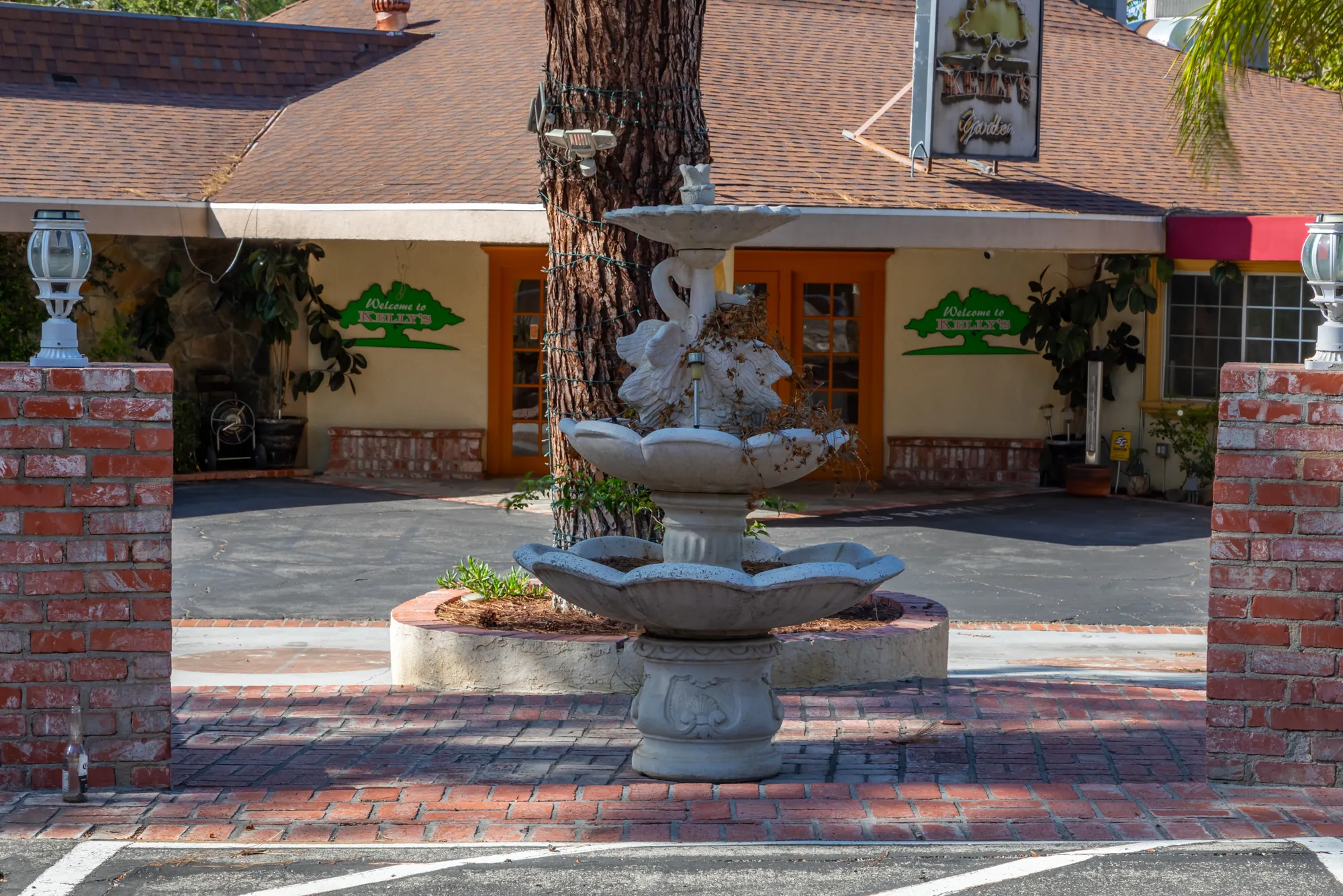 The tiered stone fountain and brick pillars in front of the entrance doors at Kelly's Wedding Garden