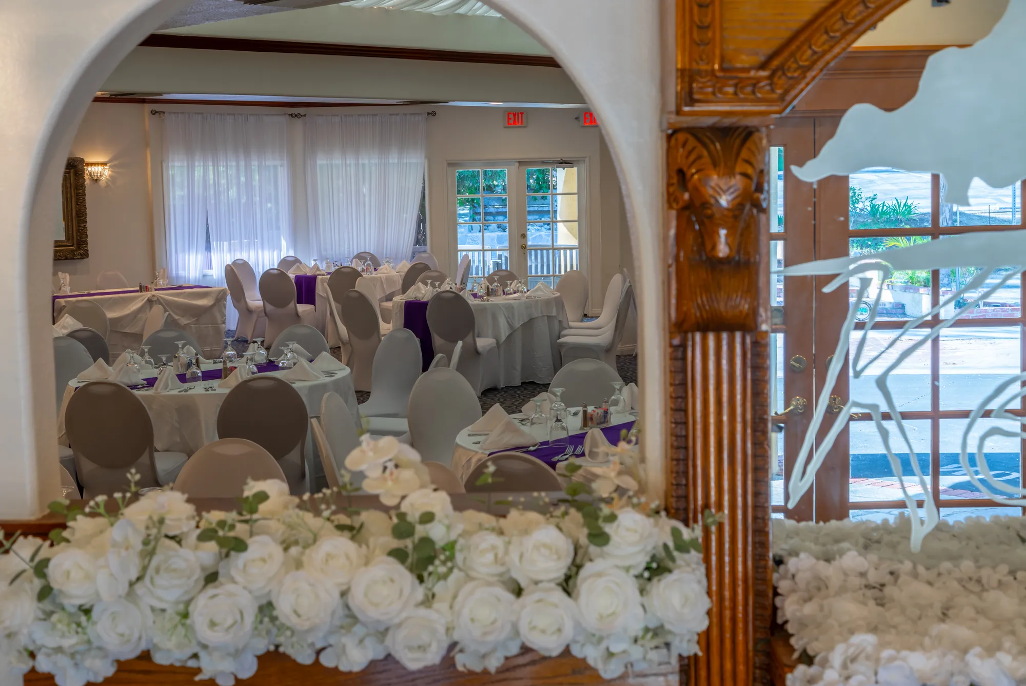 White roses in front of the arch into the banquet room at Kelly's Wedding Garden