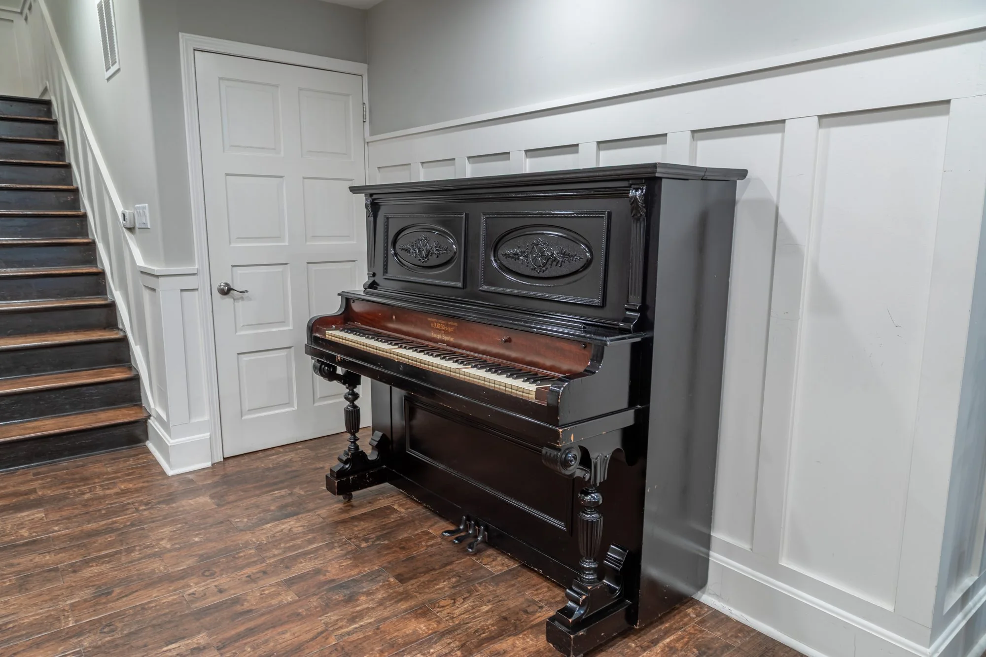 The upright piano against the panelling at Lombardi House