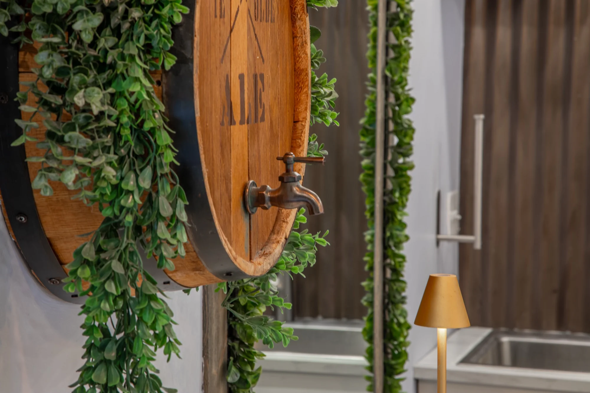 The barrel and greenery on the wall at Violet Cactus Studio