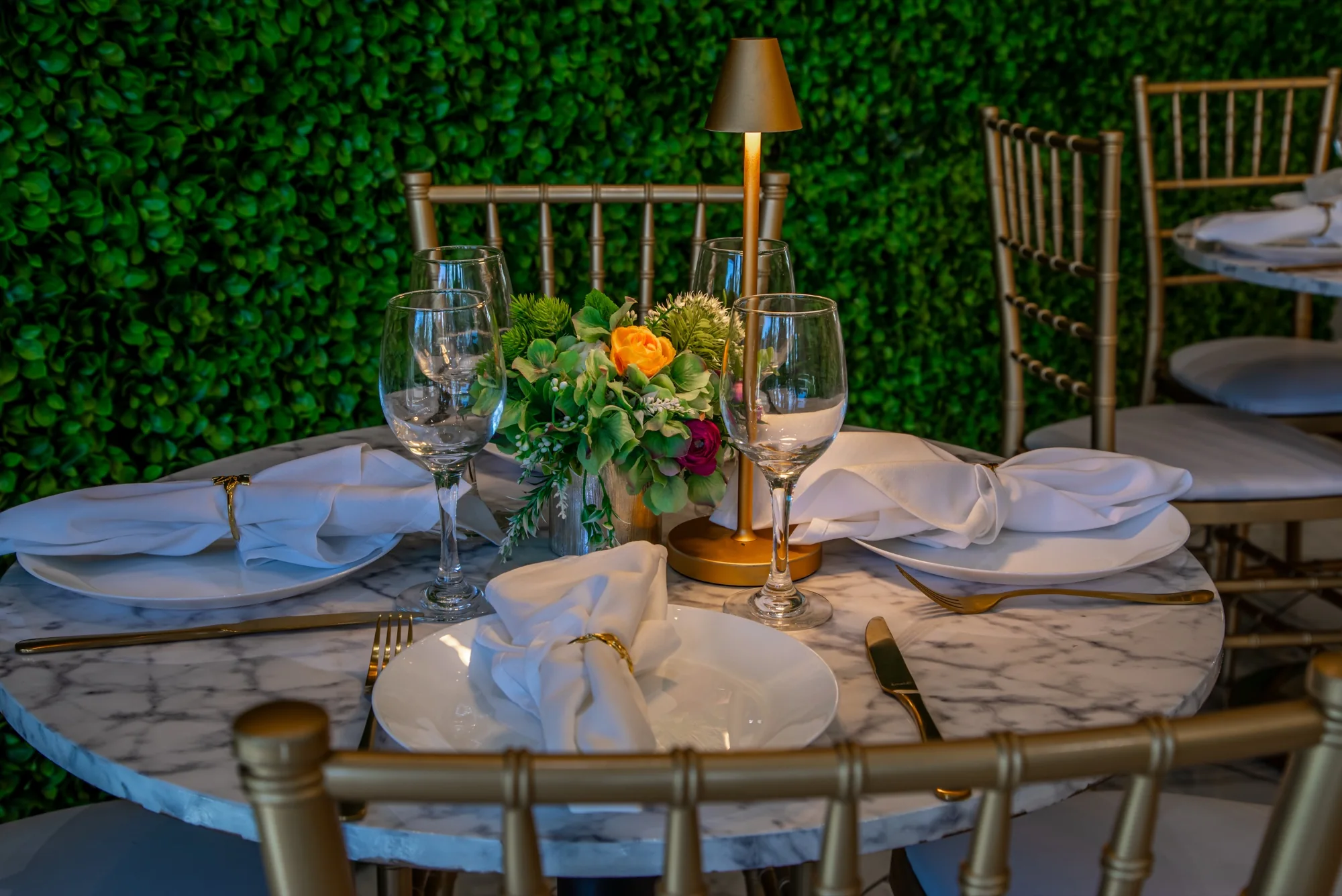 A marble table set with gold flatware at Violet Cactus Studio
